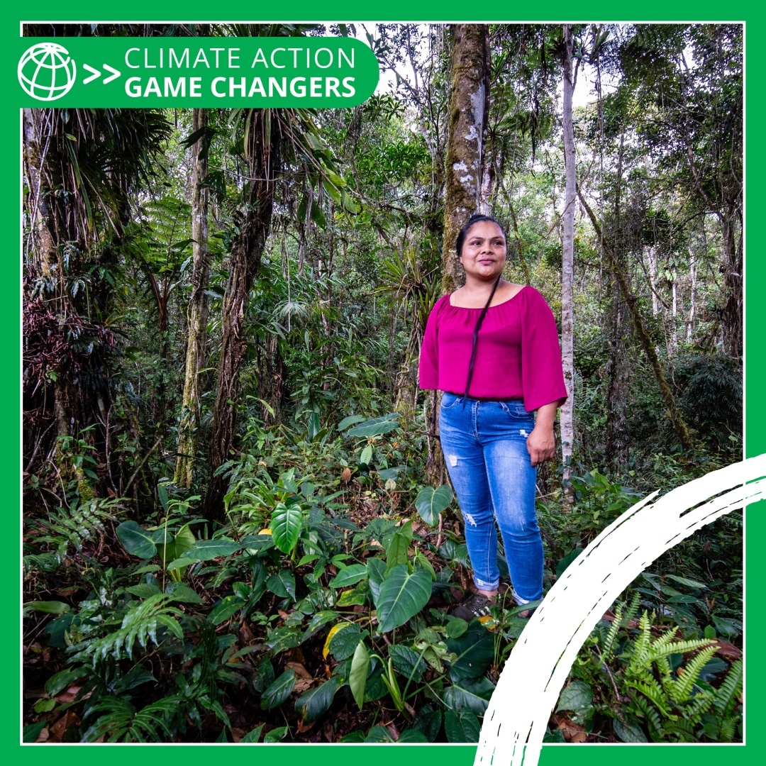 Iliana Jimenez, Community Leader and Forest Custodian, stands in the middle of a vibrant forest in Costa Rica.